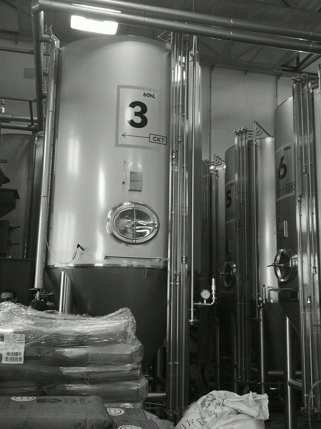 Large stainless steel fermentation tanks in an industrial brewing facility.